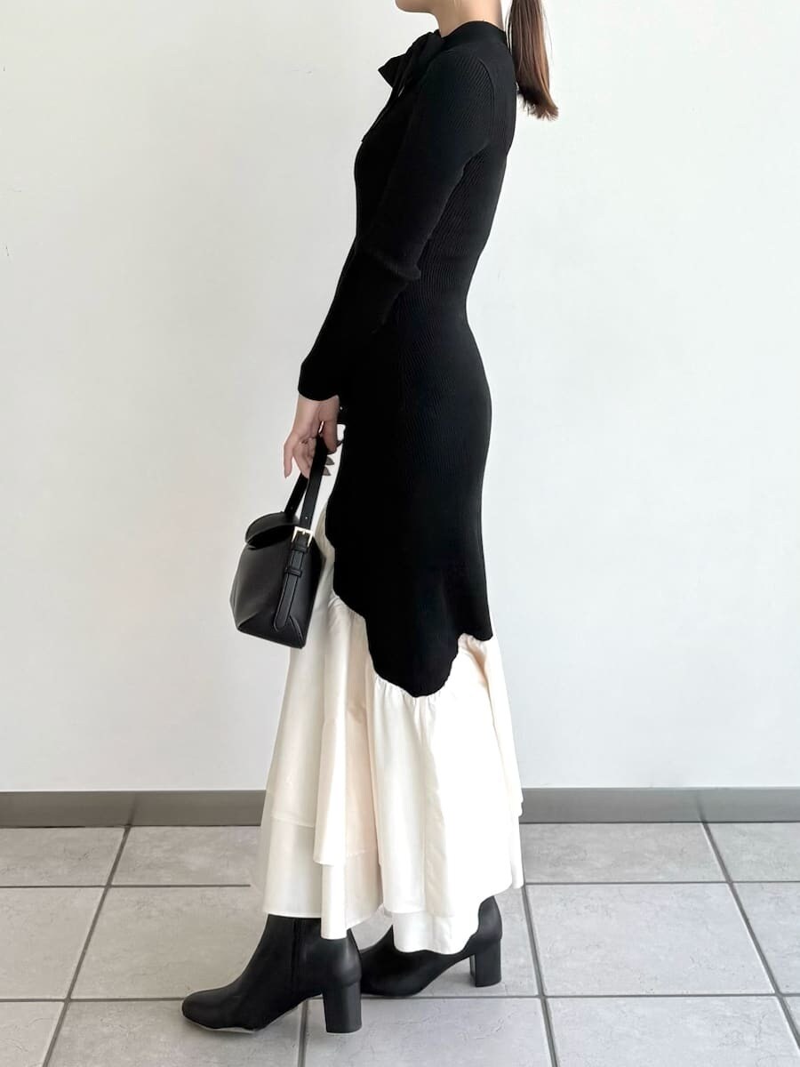 ブラック系のブーツ、その他のチェスターコート、ブラック系のハンドバッグを着用したレディースの秋コーディネートの5枚目の写真