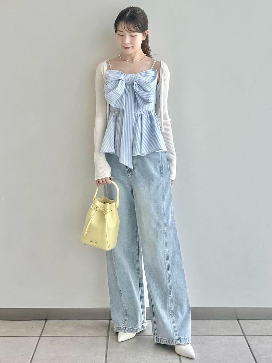 イエロー系のハンドバッグ、その他のキャミソール、ホワイト系のカーディガン/ボレロを着用したレディースの春コーディネートの2枚目の写真