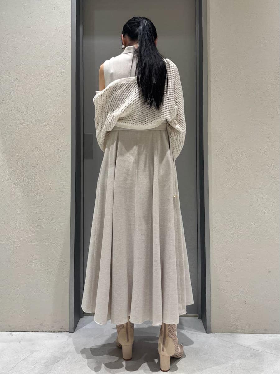 ベージュ系のワンピース、ホワイト系のカーディガン/ボレロ、グリーン系のハンドバッグを着用したレディースの春コーディネートの3枚目の写真