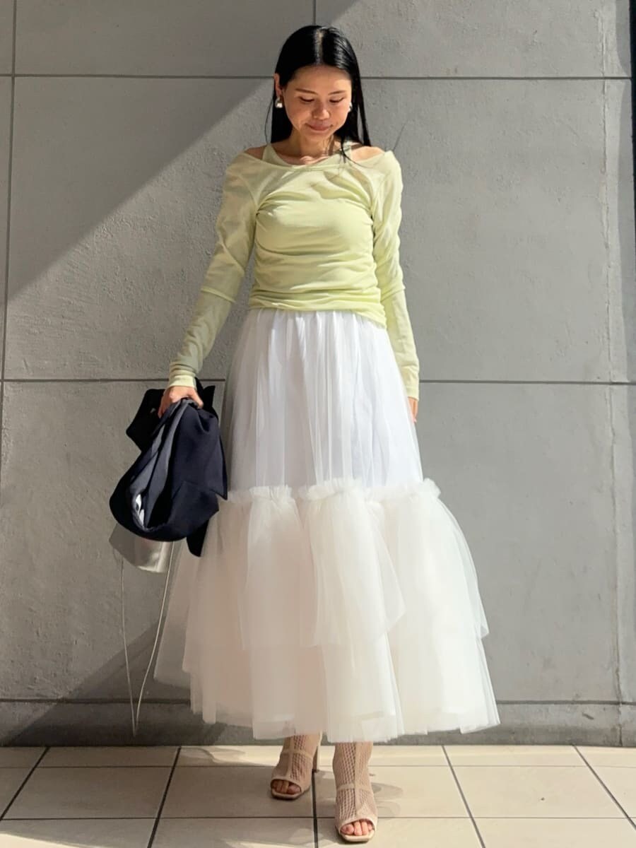 ホワイト系のスカート、グリーン系のTシャツ/カットソー、ブルー系のテーラードジャケットを着用したレディースの冬コーディネートの2枚目の写真