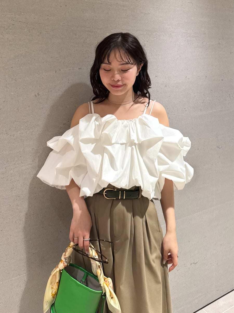 グリーン系のハンドバッグ、ホワイト系のサンダル、ホワイト系のシャツ/ブラウスを着用したレディースの冬コーディネートの9枚目の写真