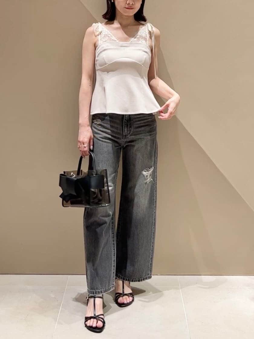 ブラック系のハンドバッグ、ブラック系のデニムパンツ、ベージュ系のその他トップスを着用したレディースの夏コーディネートの3枚目の写真