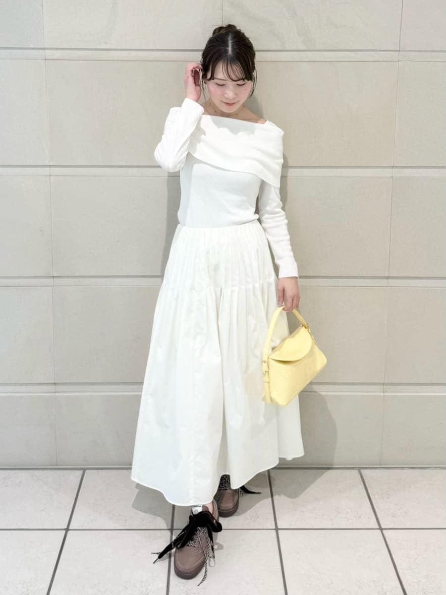 イエロー系のハンドバッグを着用したレディースの冬コーディネートの2枚目の写真