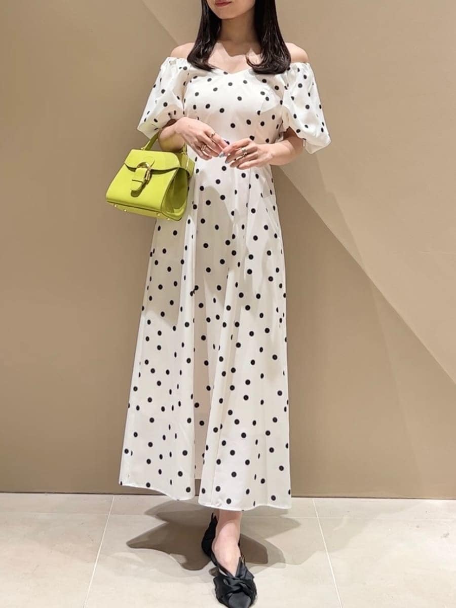 ブラック系のパンプス、その他のワンピース、グリーン系のハンドバッグを着用したレディースの春コーディネートの2枚目の写真