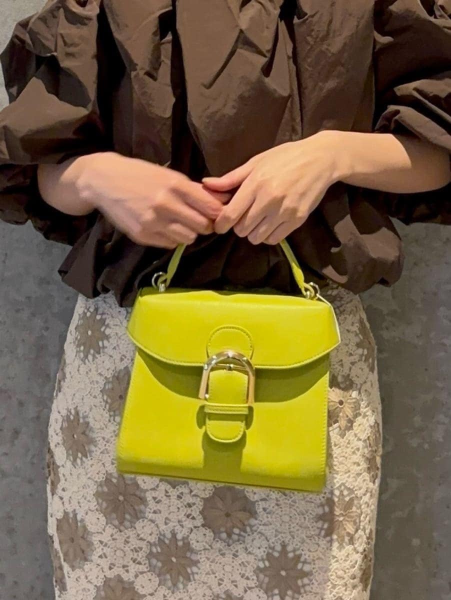 グリーン系のハンドバッグ、ブラウン系のシャツ/ブラウス、ブラウン系のサンダルを着用したレディースの春コーディネートの7枚目の写真