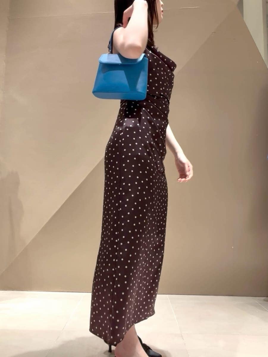 ブラック系のパンプス、ベージュ系のトレンチコート、ブラウン系のワンピースを着用したレディースの冬コーディネートの5枚目の写真