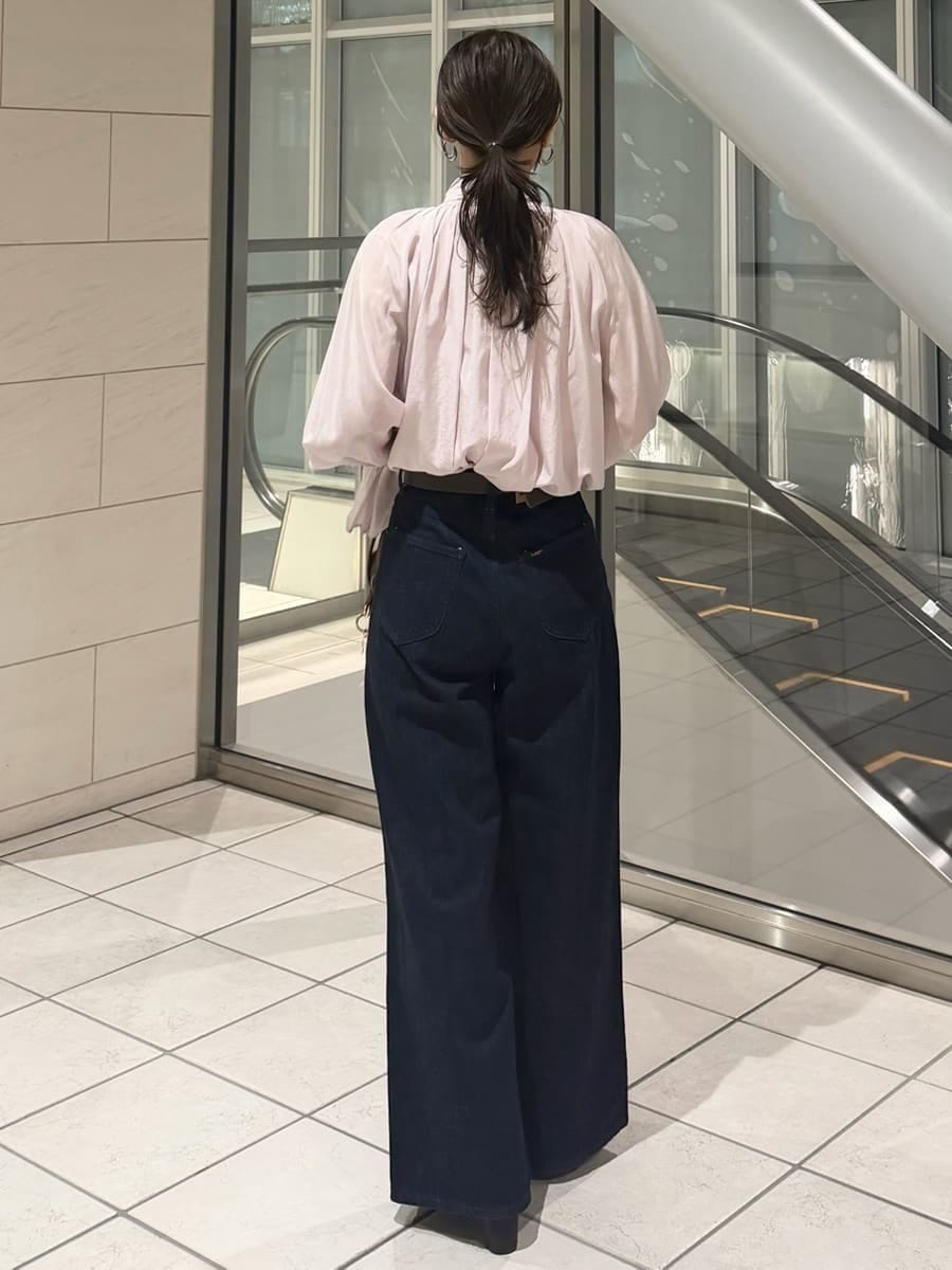 ブルー系のデニムパンツ、ブラウン系のハンドバッグ、ピンク系のシャツ/ブラウスを着用したレディースの冬コーディネートの9枚目の写真