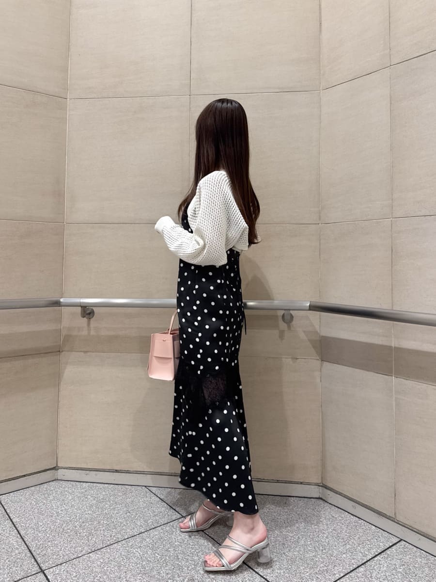 ブラック系のワンピース、ホワイト系のカーディガン/ボレロ、シルバー系のサンダルを着用したレディースの春コーディネートの4枚目の写真