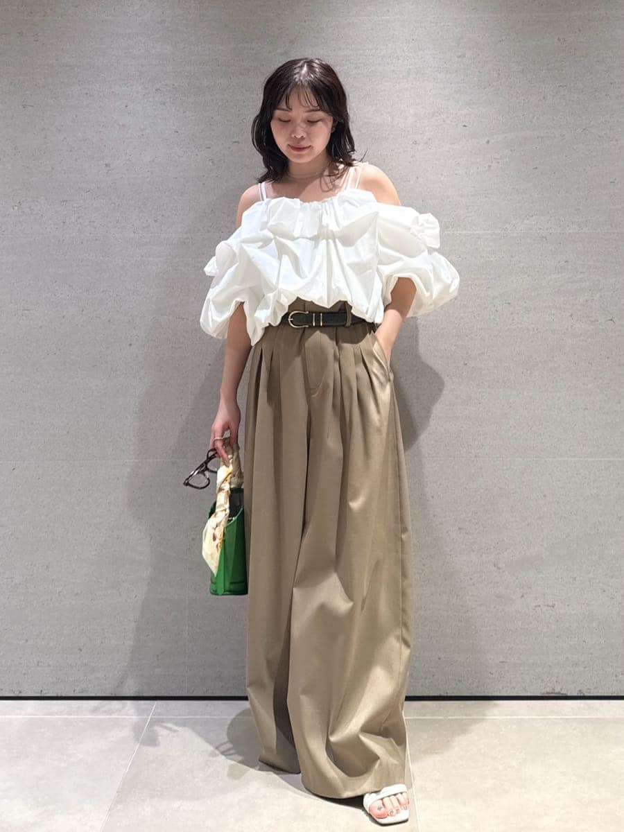 グリーン系のハンドバッグ、ホワイト系のサンダル、ホワイト系のシャツ/ブラウスを着用したレディースの冬コーディネートの4枚目の写真