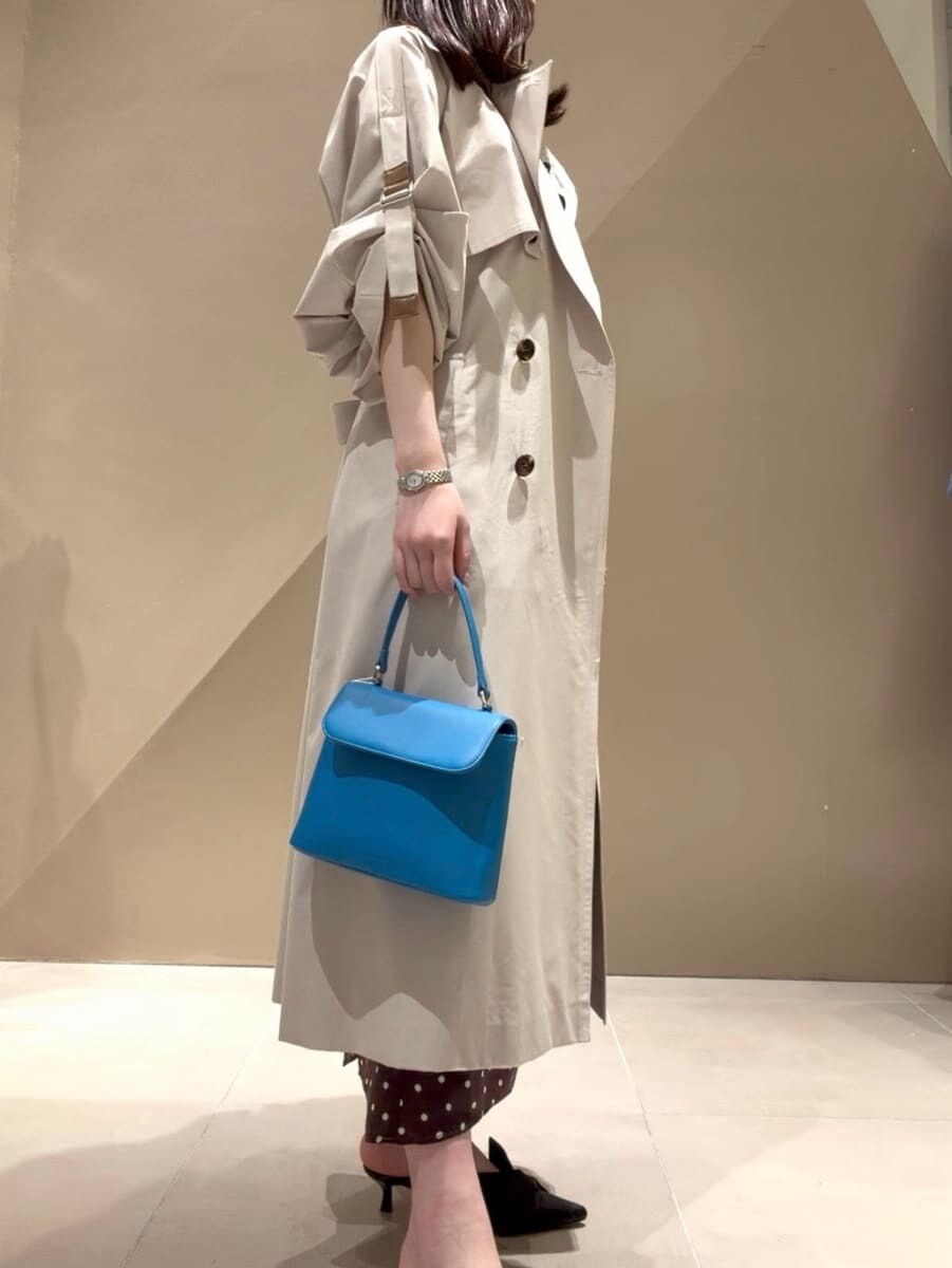 ブラック系のパンプス、ベージュ系のトレンチコート、ブラウン系のワンピースを着用したレディースの冬コーディネートの8枚目の写真