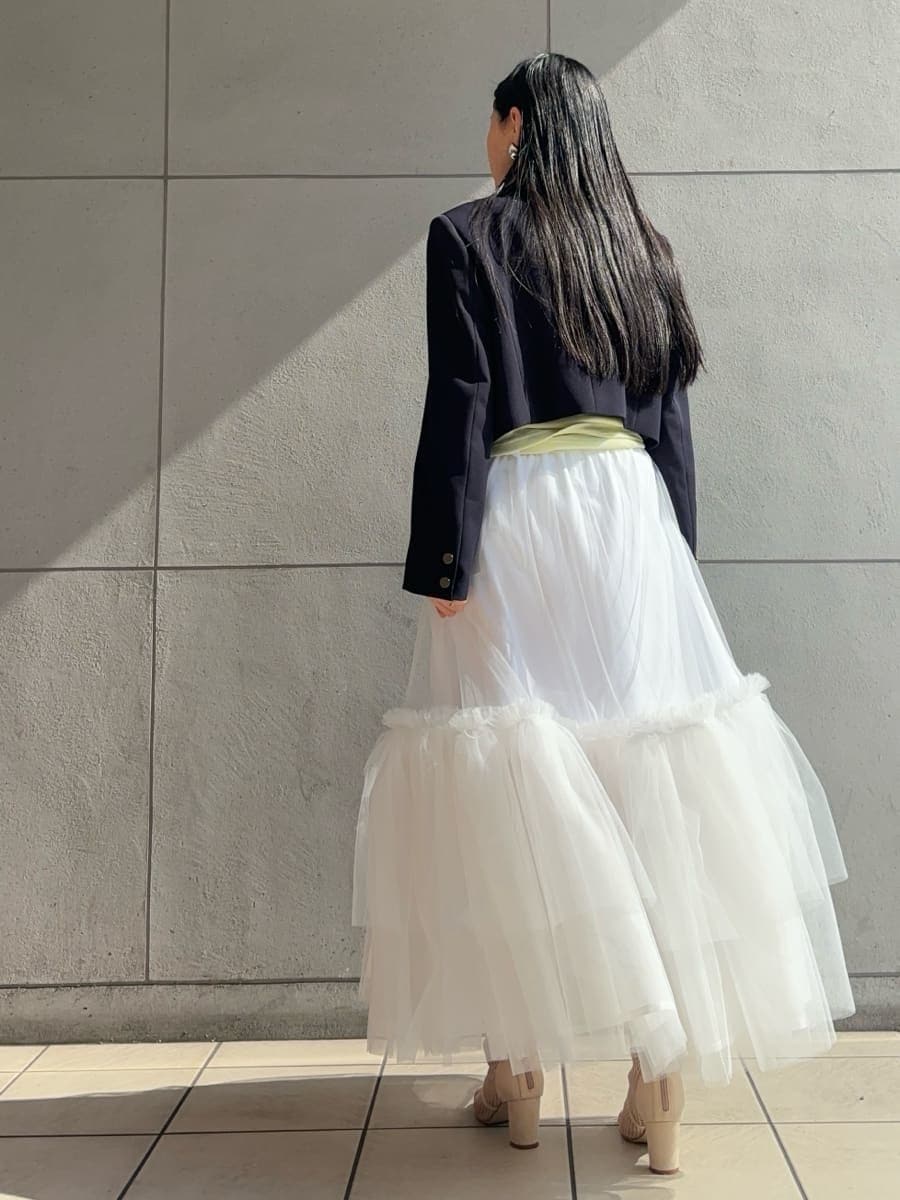 ホワイト系のスカート、グリーン系のTシャツ/カットソー、ブルー系のテーラードジャケットを着用したレディースの冬コーディネートの5枚目の写真