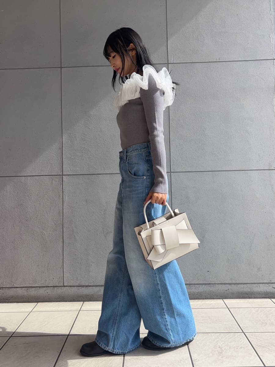 ブルー系のデニムパンツ、ベージュ系のトレンチコート、グレー系のニット/セーターを着用したレディースの冬コーディネートの3枚目の写真