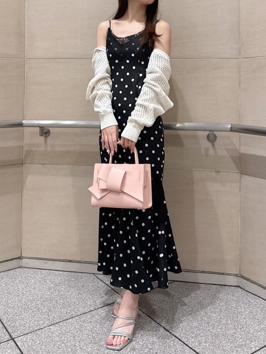 ブラック系のワンピース、ホワイト系のカーディガン/ボレロ、シルバー系のサンダルを着用したレディースの春コーディネートの2枚目の写真