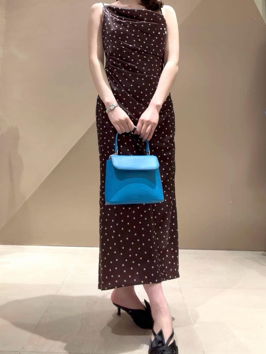 ブラック系のパンプス、ベージュ系のトレンチコート、ブラウン系のワンピースを着用したレディースの冬コーディネートの6枚目の写真