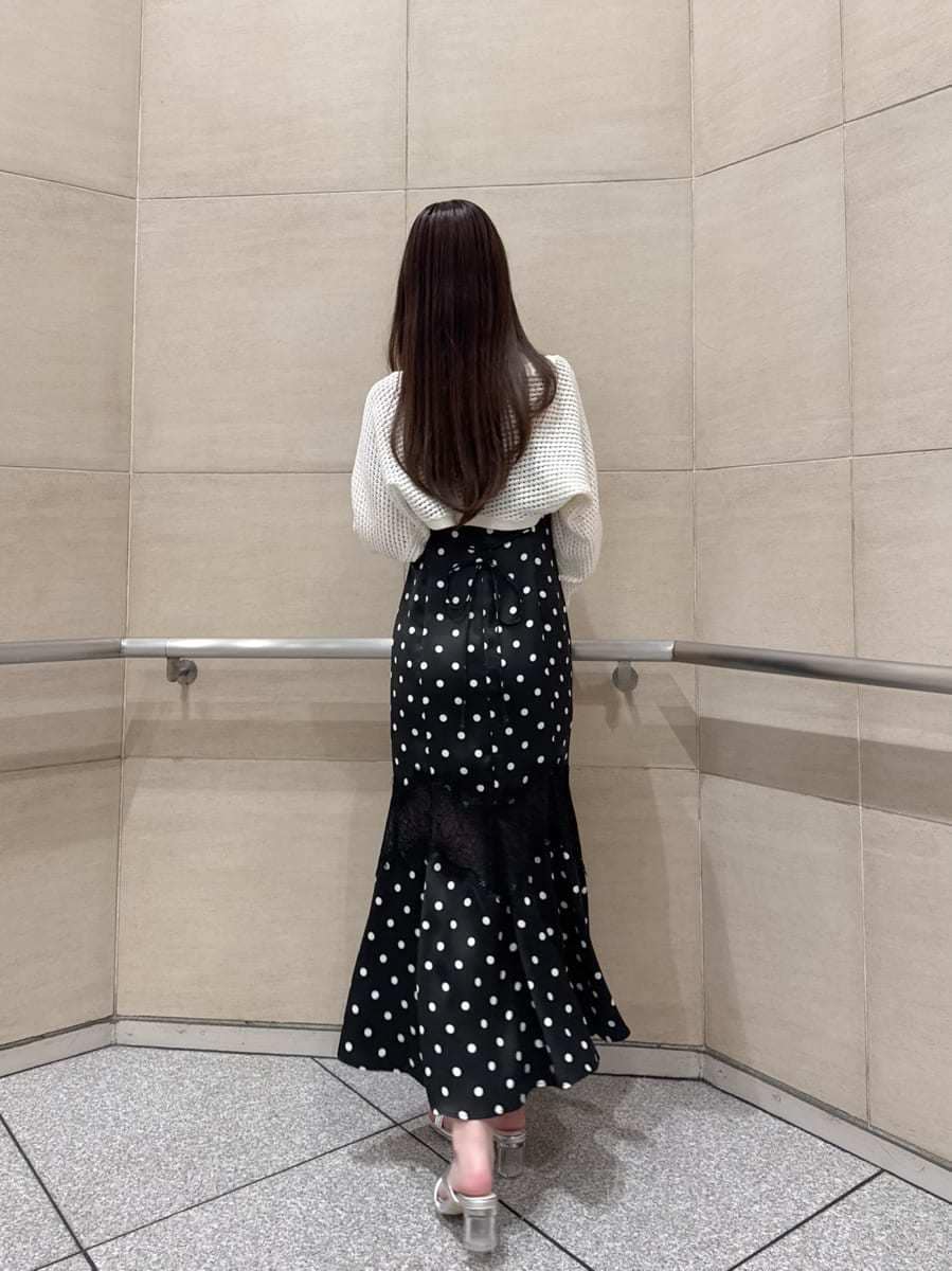 ブラック系のワンピース、ホワイト系のカーディガン/ボレロ、シルバー系のサンダルを着用したレディースの春コーディネートの5枚目の写真