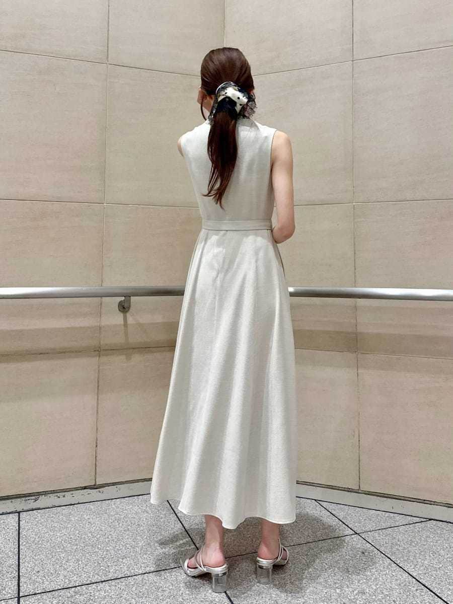 ベージュ系のワンピース、シルバー系のサンダル、その他のシュシュを着用したレディースの春コーディネートの5枚目の写真