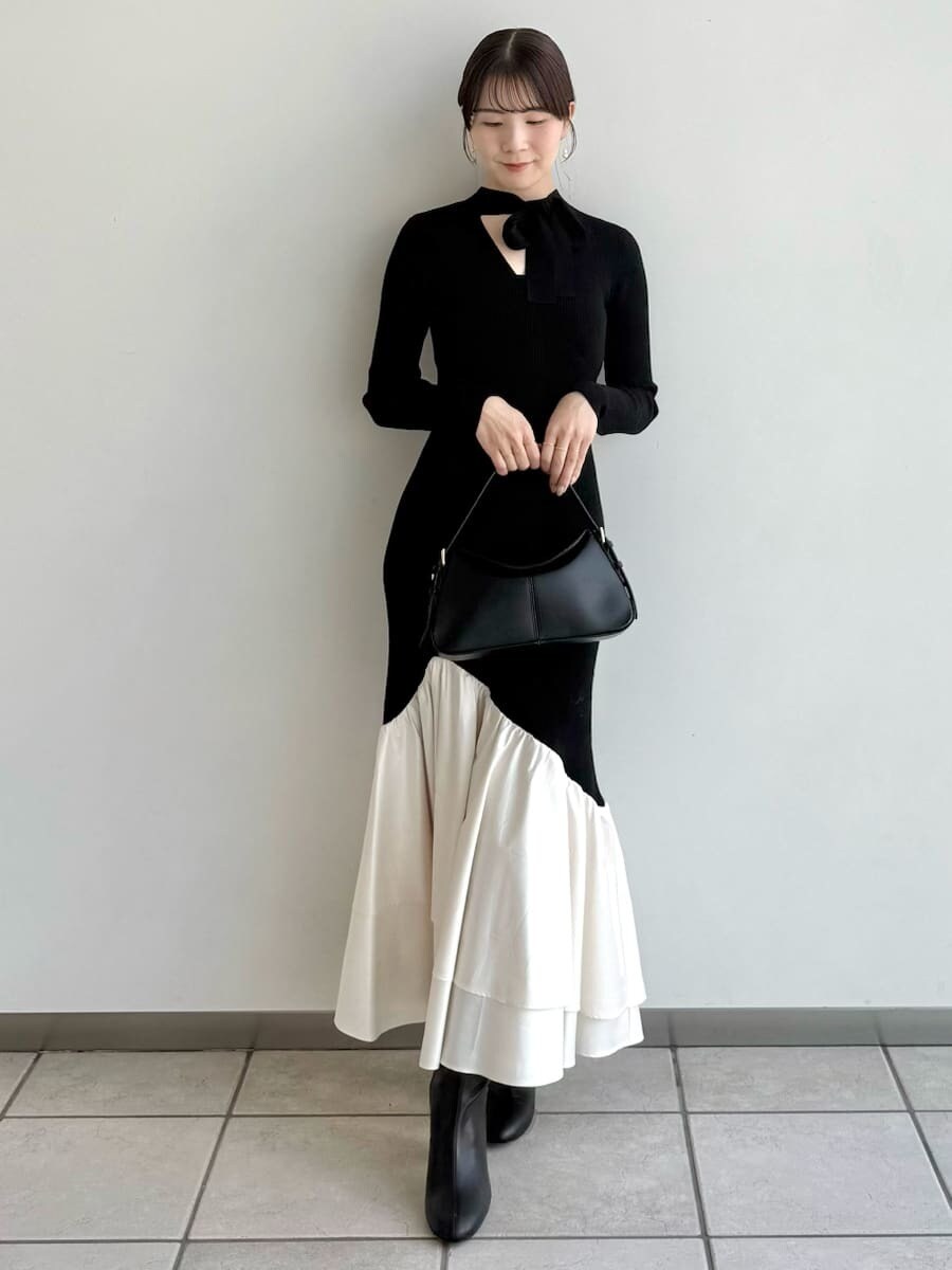 ブラック系のブーツ、その他のチェスターコート、ブラック系のハンドバッグを着用したレディースの秋コーディネートの4枚目の写真