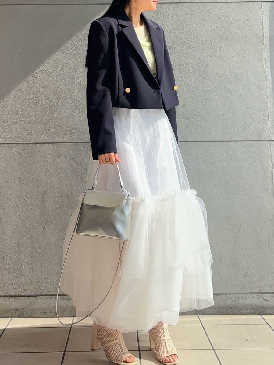 ホワイト系のスカート、グリーン系のTシャツ/カットソー、ブルー系のテーラードジャケットを着用したレディースの冬コーディネートの3枚目の写真