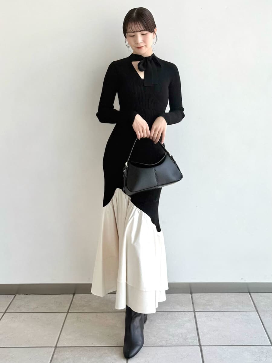 ブラック系のブーツ、その他のチェスターコート、ブラック系のハンドバッグを着用したレディースの秋コーディネートの7枚目の写真