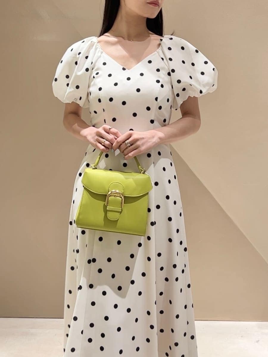 ブラック系のパンプス、その他のワンピース、グリーン系のハンドバッグを着用したレディースの春コーディネートの5枚目の写真