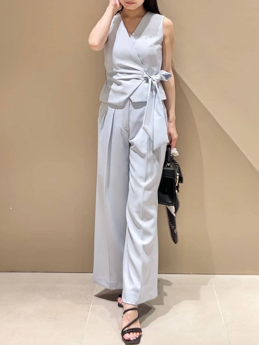 ブラック系のハンドバッグ、ブラック系のサンダル、ブルー系のテーラードジャケットを着用したレディースの春コーディネートの3枚目の写真