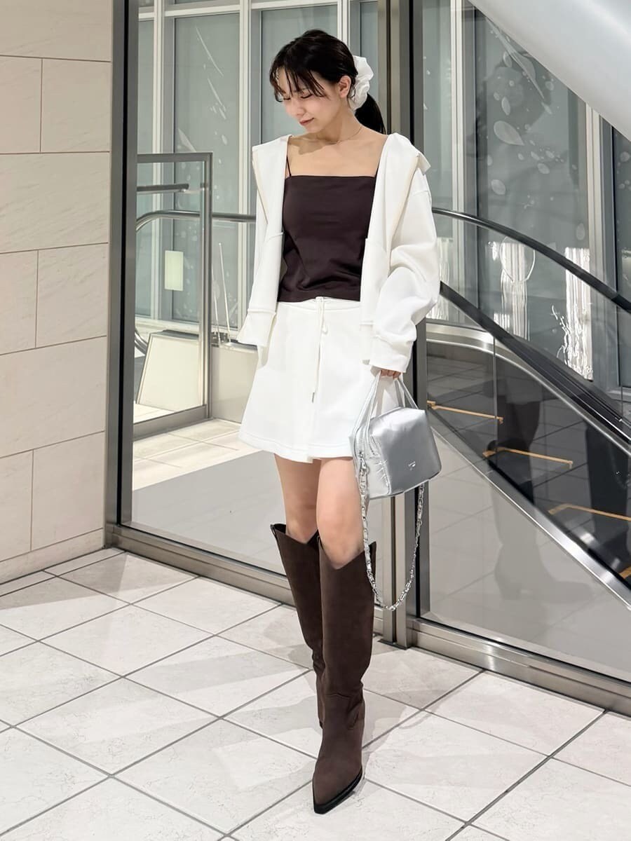 ブラウン系のブーツ、シルバー系のハンドバッグ、ホワイト系のパーカーを着用したレディースの冬コーディネートの3枚目の写真