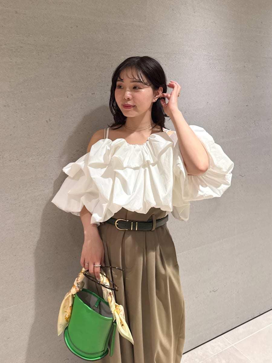 グリーン系のハンドバッグ、ホワイト系のサンダル、ホワイト系のシャツ/ブラウスを着用したレディースの冬コーディネートの8枚目の写真