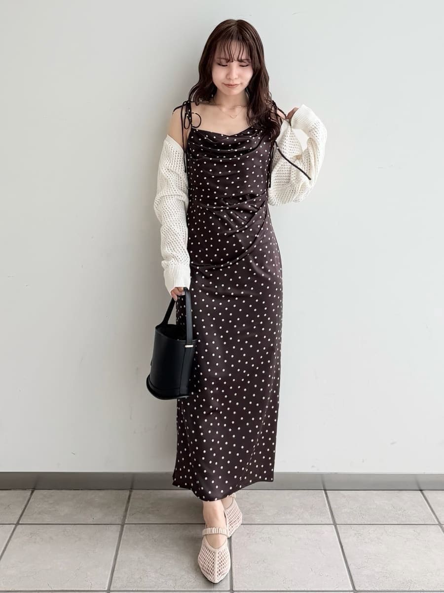 ブラウン系のワンピース、ホワイト系のカーディガン/ボレロ、ブラック系のハンドバッグを着用したレディースの冬コーディネートの2枚目の写真