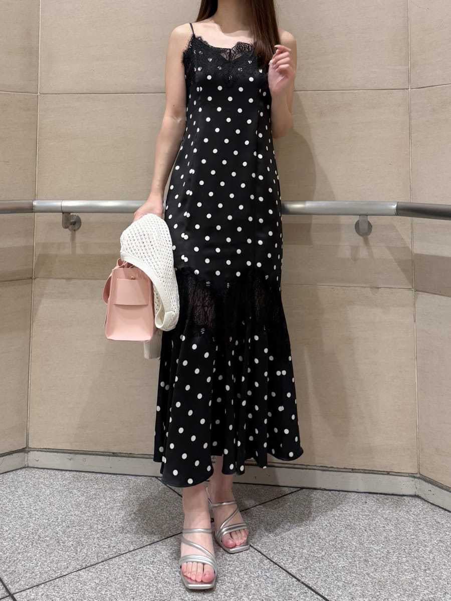 ブラック系のワンピース、ホワイト系のカーディガン/ボレロ、シルバー系のサンダルを着用したレディースの春コーディネートの6枚目の写真