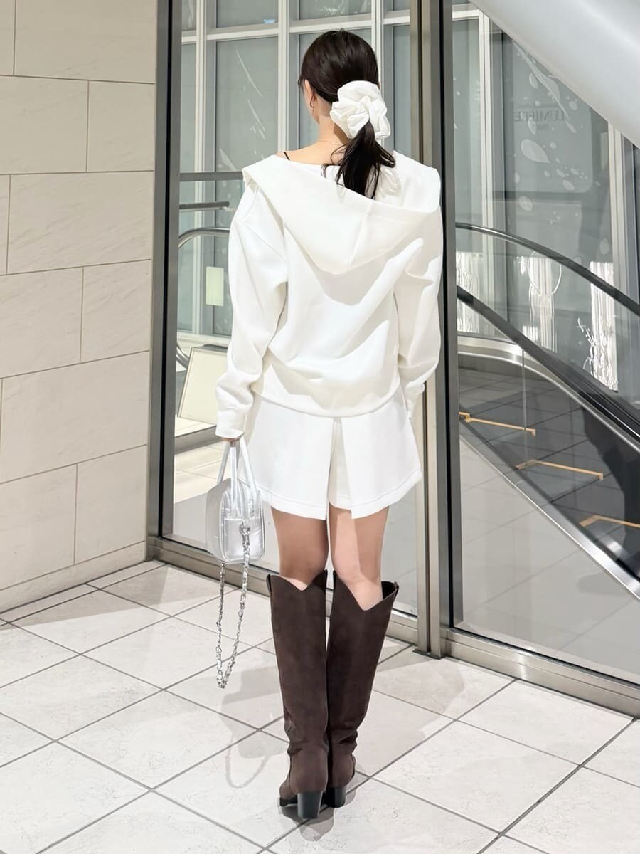 ブラウン系のブーツ、シルバー系のハンドバッグ、ホワイト系のパーカーを着用したレディースの冬コーディネートの7枚目の写真