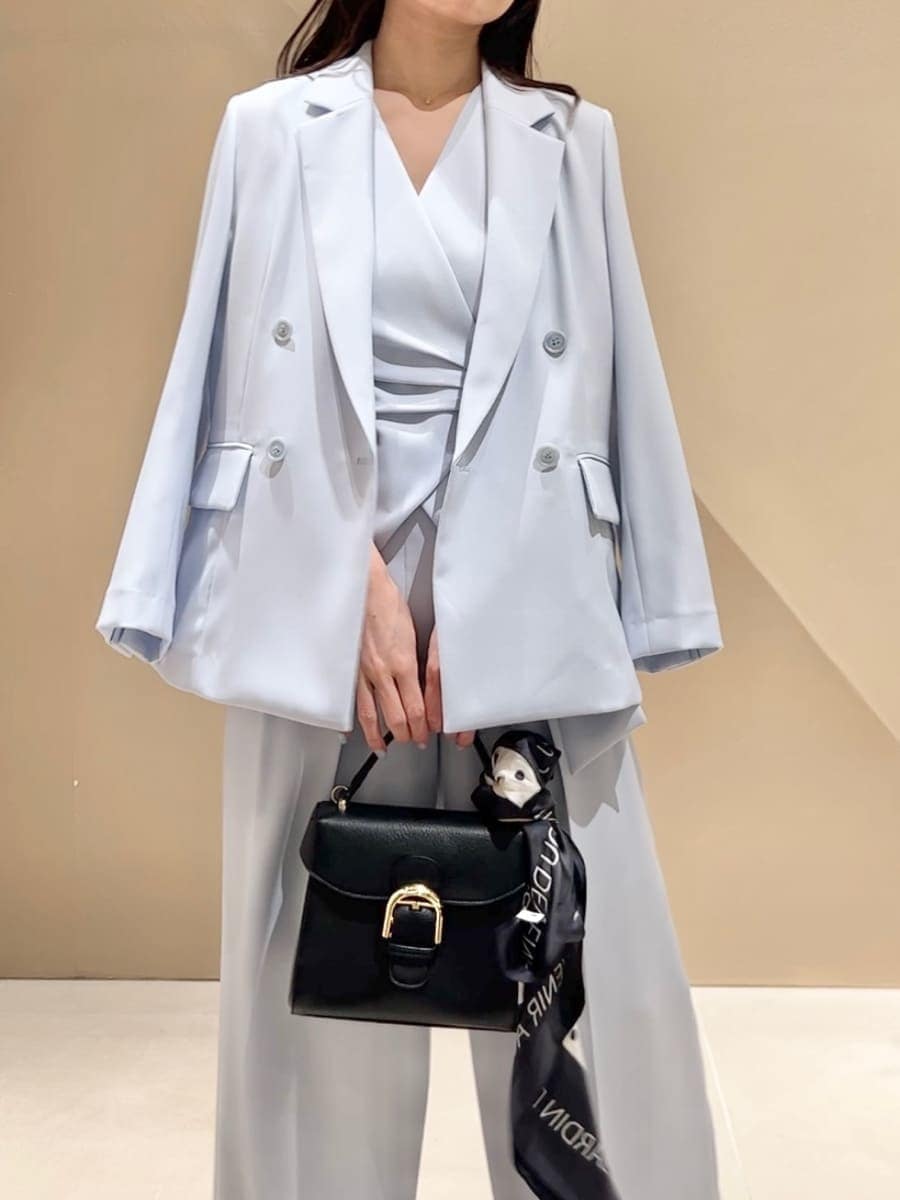 ブラック系のハンドバッグ、ブラック系のサンダル、ブルー系のテーラードジャケットを着用したレディースの春コーディネートの5枚目の写真