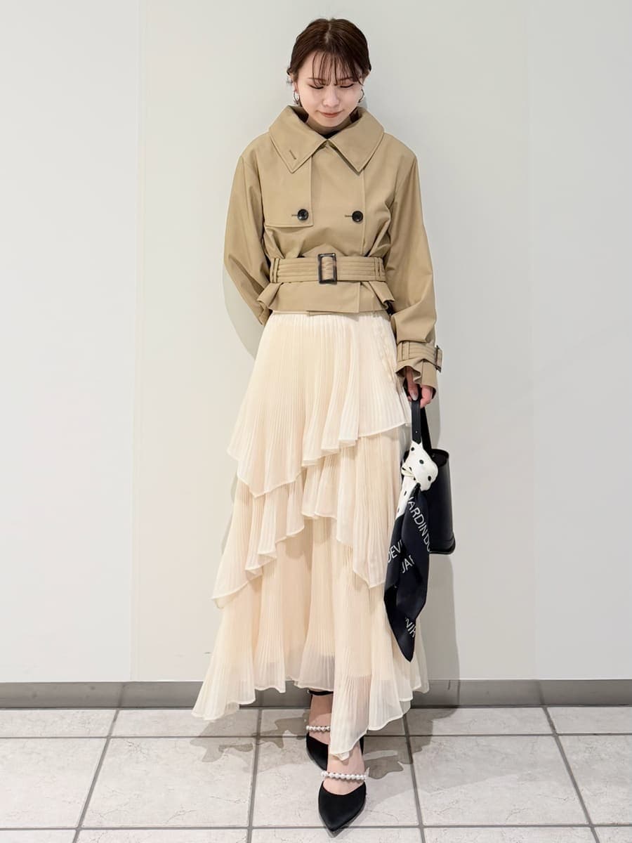 ベージュ系のスカート、ベージュ系のトレンチコート、ブラック系のニット/セーターを着用したレディースの冬コーディネートの6枚目の写真