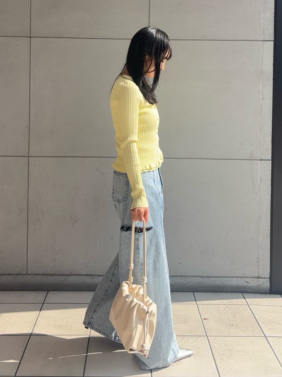 ブルー系のデニムパンツ、イエロー系のニット/セーターを着用したレディースの冬コーディネートの2枚目の写真