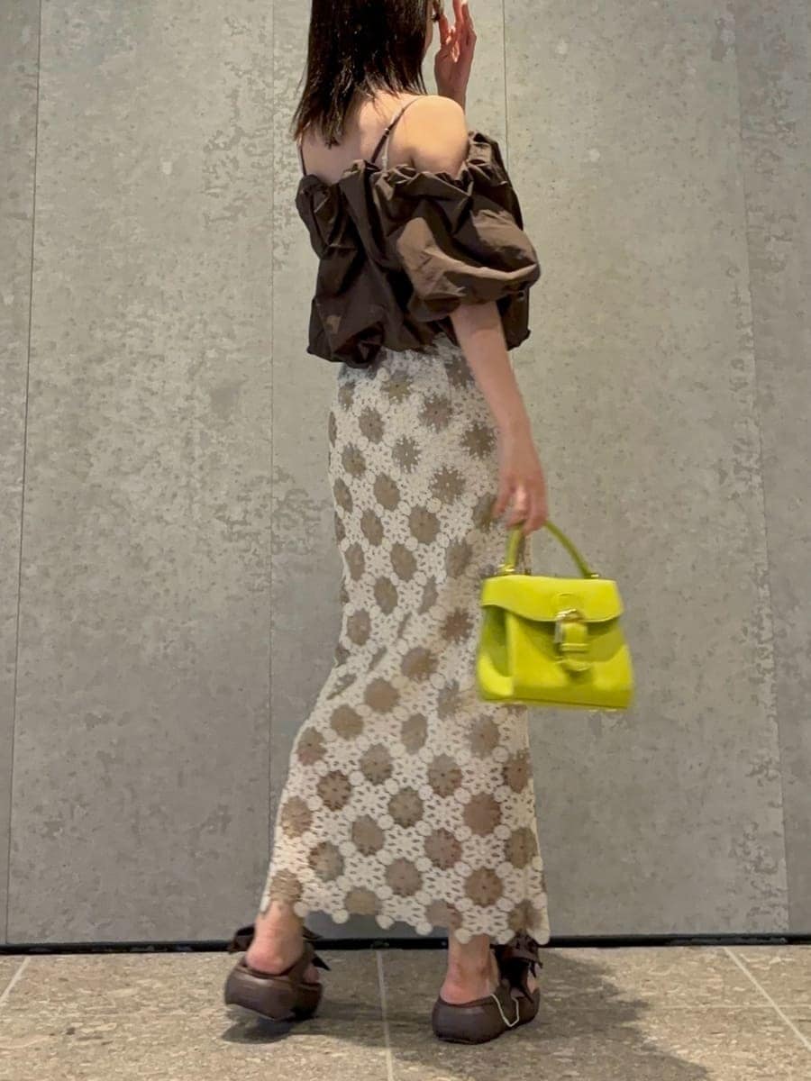 グリーン系のハンドバッグ、ブラウン系のシャツ/ブラウス、ブラウン系のサンダルを着用したレディースの春コーディネートの3枚目の写真