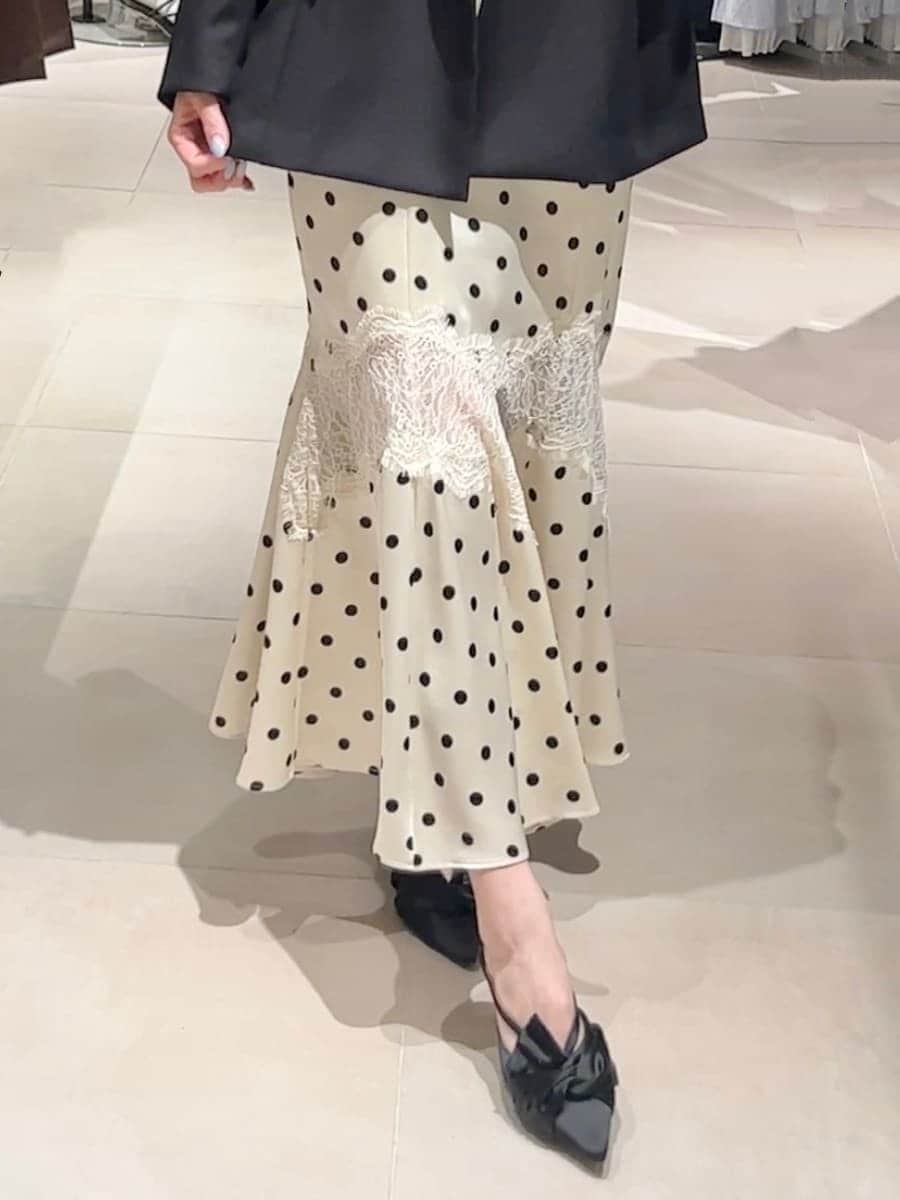 ブラック系のパンプス、ホワイト系のワンピース、グリーン系のカーディガン/ボレロを着用したレディースの春コーディネートの8枚目の写真