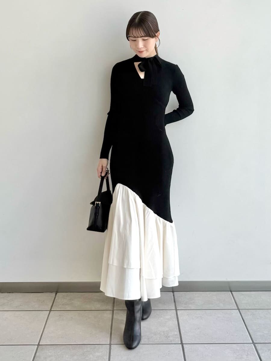 ブラック系のブーツ、その他のチェスターコート、ブラック系のハンドバッグを着用したレディースの秋コーディネートの3枚目の写真