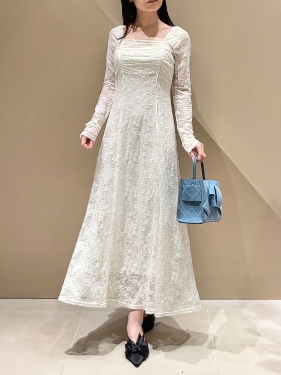 ブラック系のパンプス、ブルー系のトレンチコート、ホワイト系のワンピースを着用したレディースの冬コーディネートの9枚目の写真