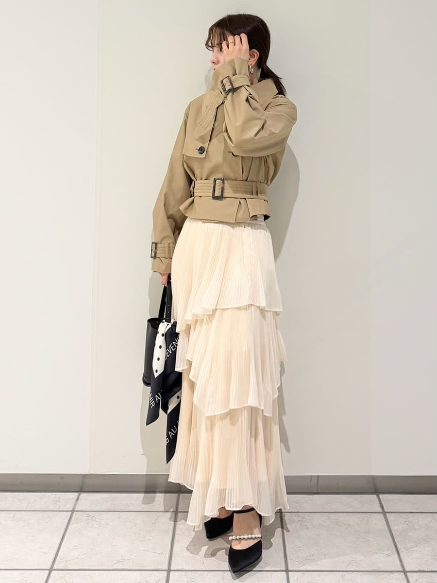 ベージュ系のスカート、ベージュ系のトレンチコート、ブラック系のニット/セーターを着用したレディースの冬コーディネートの7枚目の写真