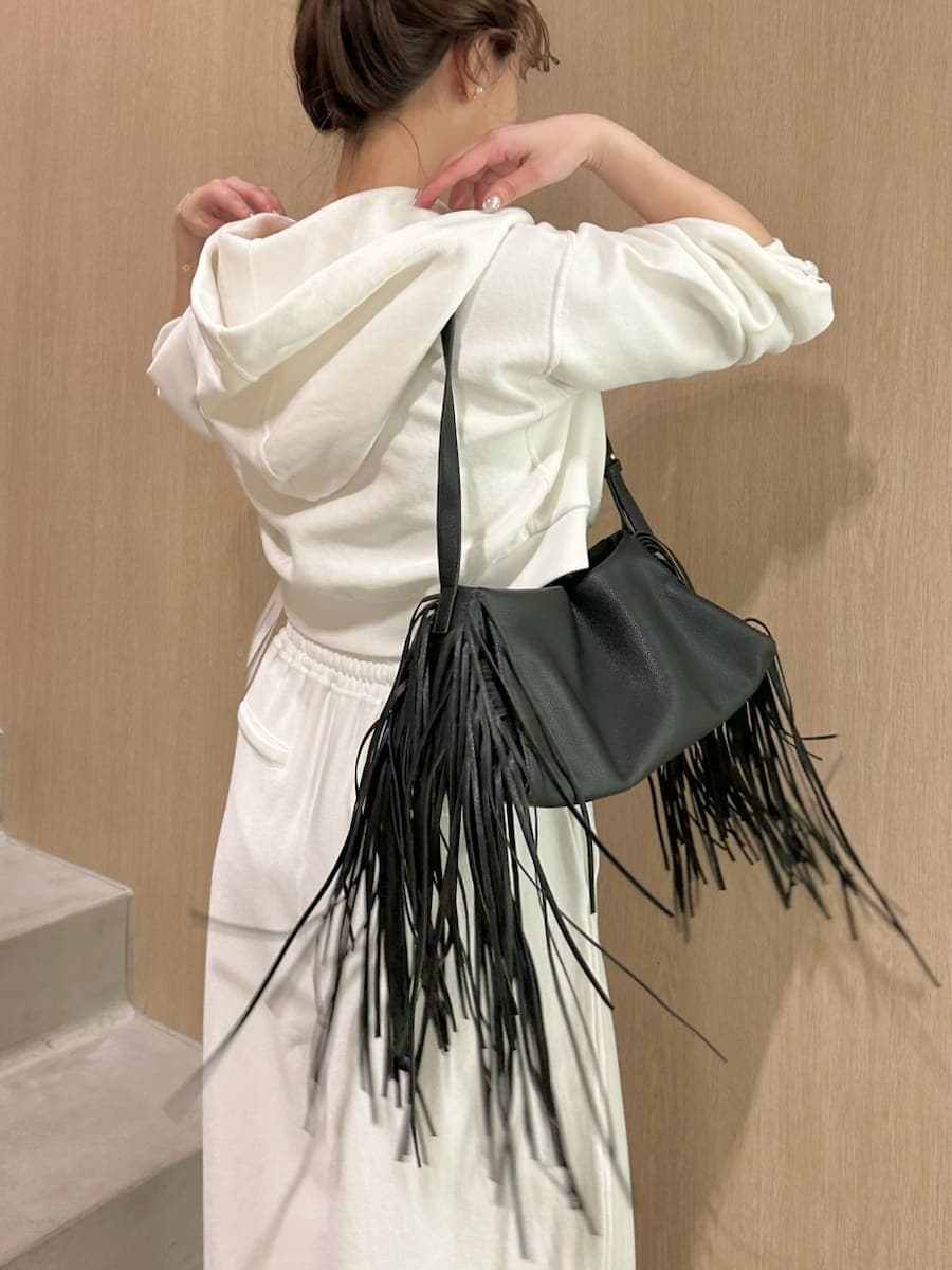 ホワイト系のスウェット、ホワイト系のその他パンツ、ブラック系のハンドバッグを着用したレディースの冬コーディネートの3枚目の写真