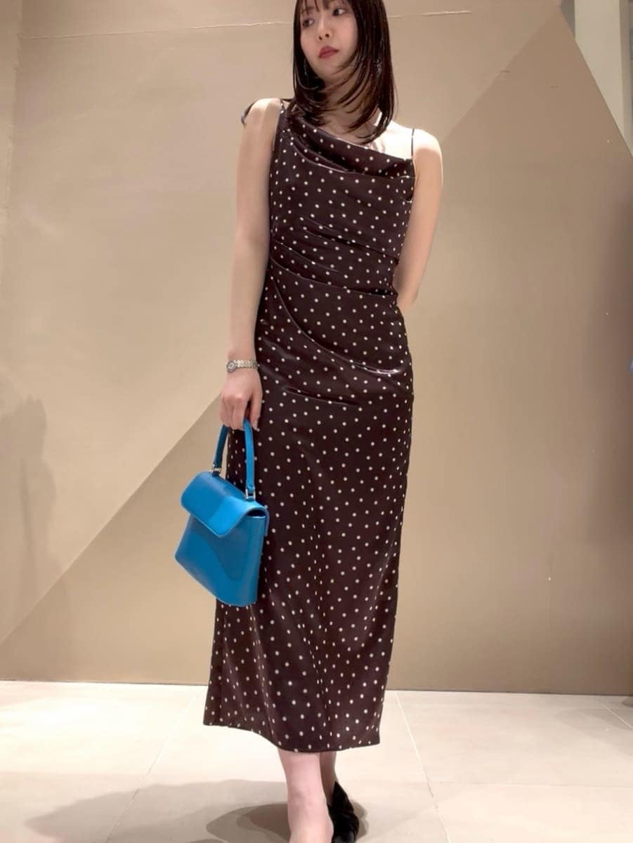 ブラック系のパンプス、ベージュ系のトレンチコート、ブラウン系のワンピースを着用したレディースの冬コーディネートの2枚目の写真