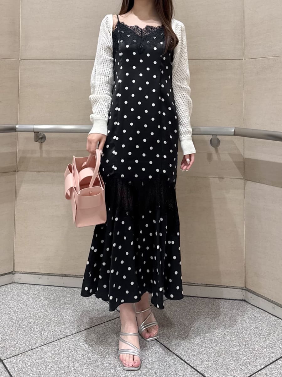 ブラック系のワンピース、ホワイト系のカーディガン/ボレロ、シルバー系のサンダルを着用したレディースの春コーディネートの3枚目の写真