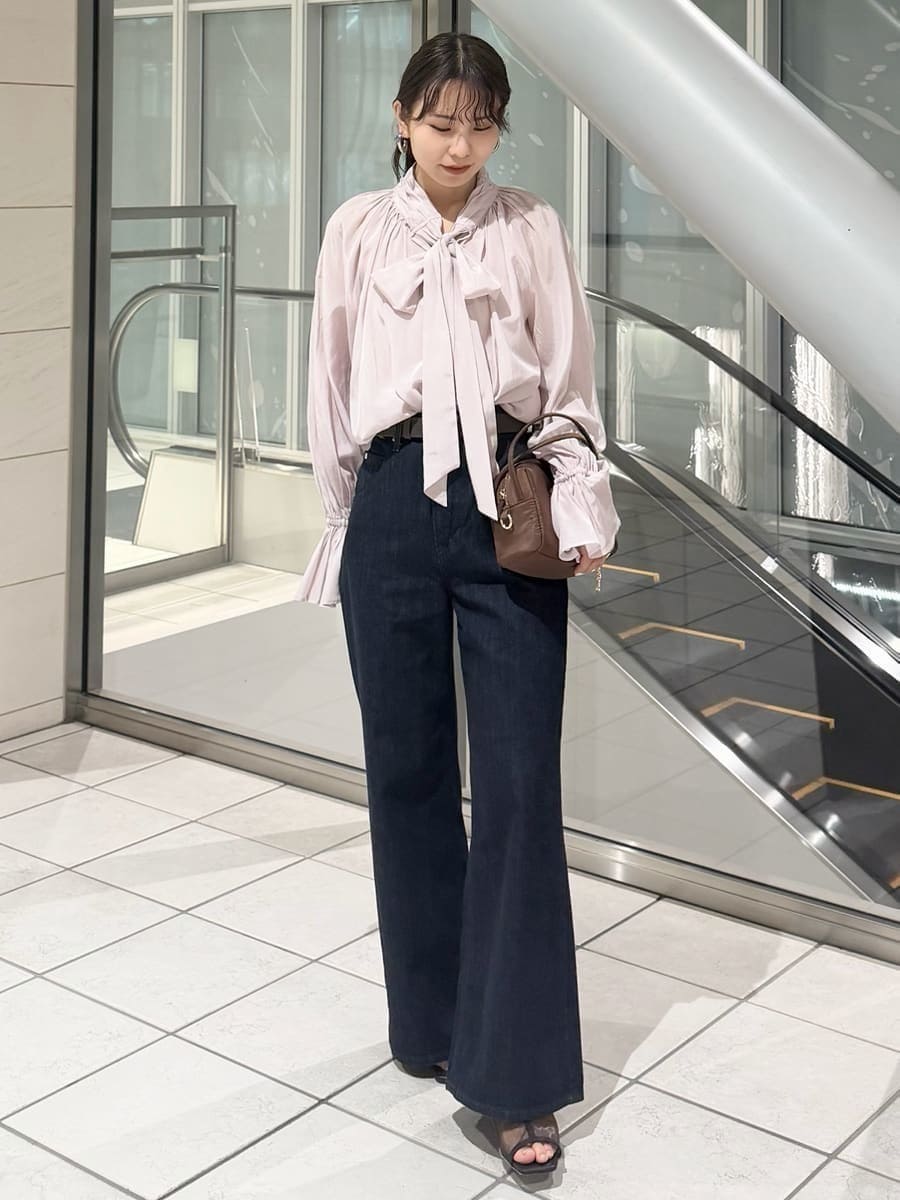 ブルー系のデニムパンツ、ブラウン系のハンドバッグ、ピンク系のシャツ/ブラウスを着用したレディースの冬コーディネートの7枚目の写真