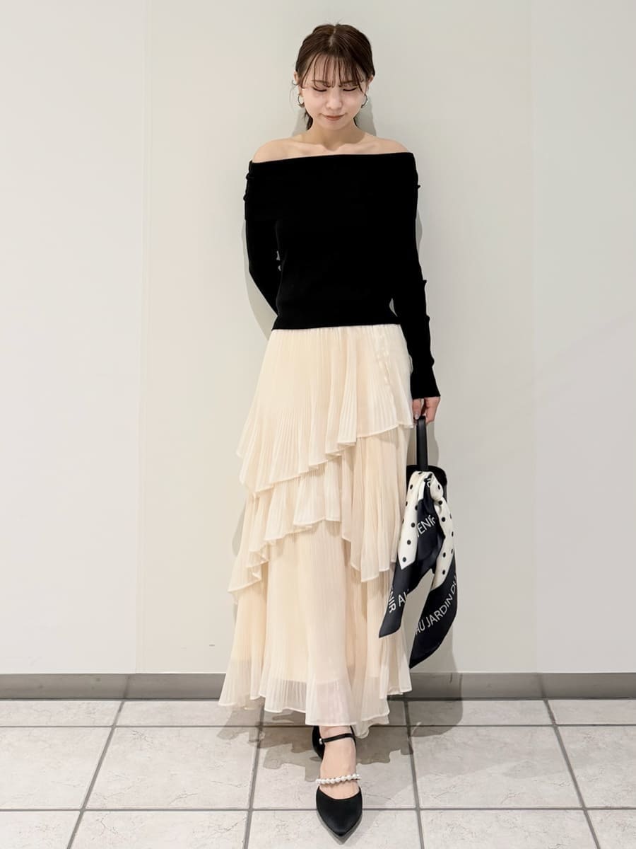 ベージュ系のスカート、ベージュ系のトレンチコート、ブラック系のニット/セーターを着用したレディースの冬コーディネートの3枚目の写真