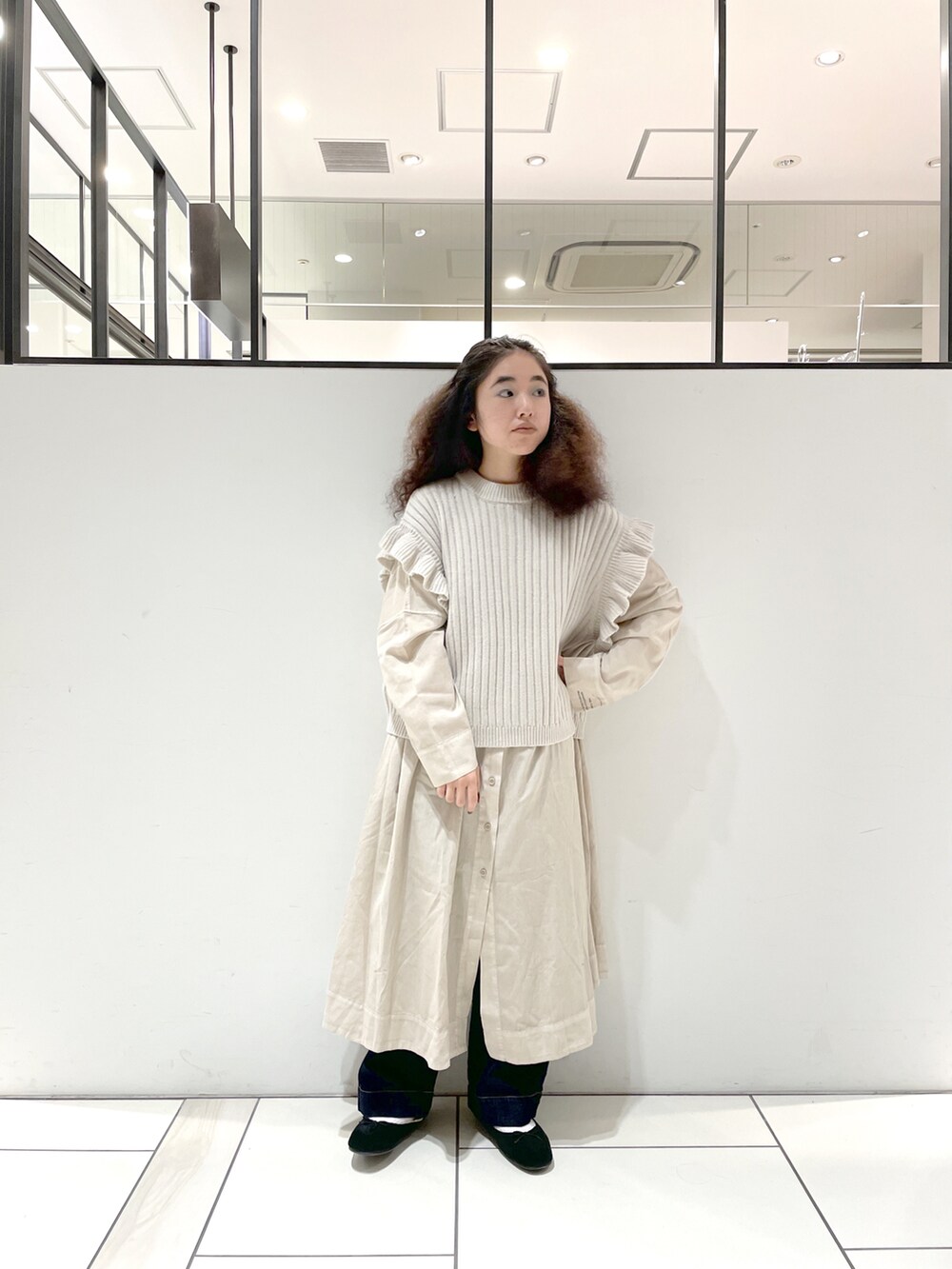 ベージュ系のニット/セーター、ベージュ系のワンピース、ブルー系のデニムパンツを着用したレディースの秋コーディネートの2枚目の写真