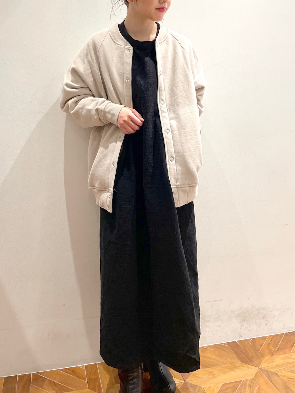 ブラック系のワンピース、ベージュ系のブルゾンを着用したレディースの冬コーディネートの2枚目の写真