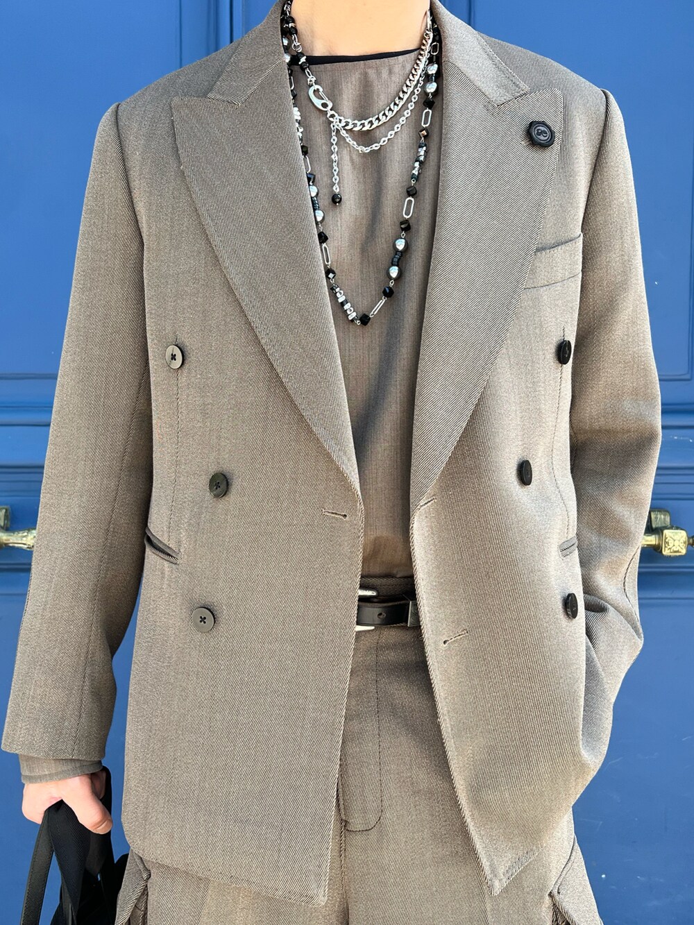 ベージュ系のテーラードジャケット、ベージュ系のスラックスを着用したメンズの夏コーディネートの2枚目の写真