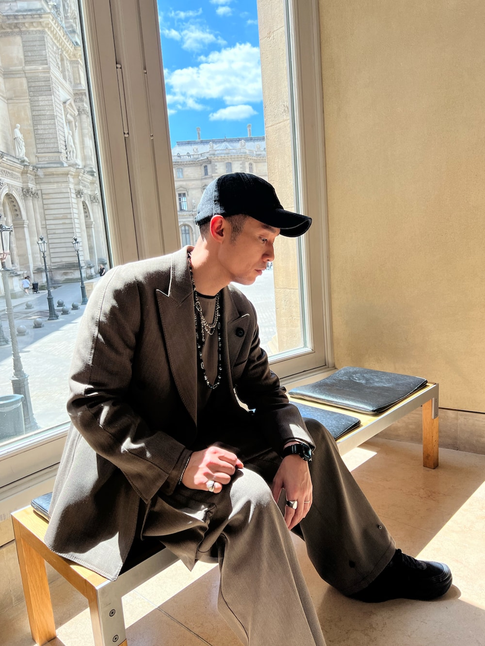 ベージュ系のテーラードジャケット、ベージュ系のスラックスを着用したメンズの夏コーディネートの3枚目の写真