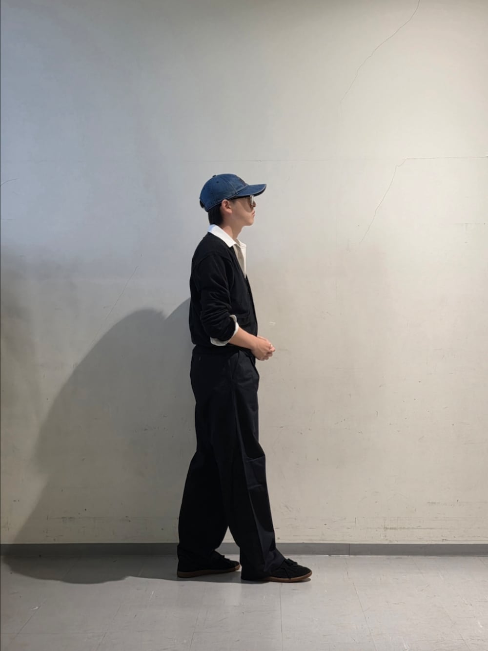 ブラック系のカーディガン/ボレロ、ブルー系のチノパンツ、ブラック系のスニーカーを着用したメンズの夏コーディネートの4枚目の写真