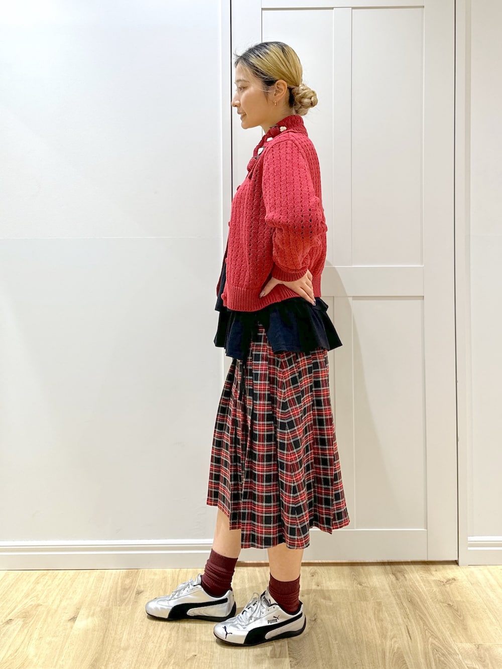 レッド系のカーディガン/ボレロ、ホワイト系のTシャツ/カットソー、ブラック系のスカートを着用したレディースの秋コーディネートの5枚目の写真