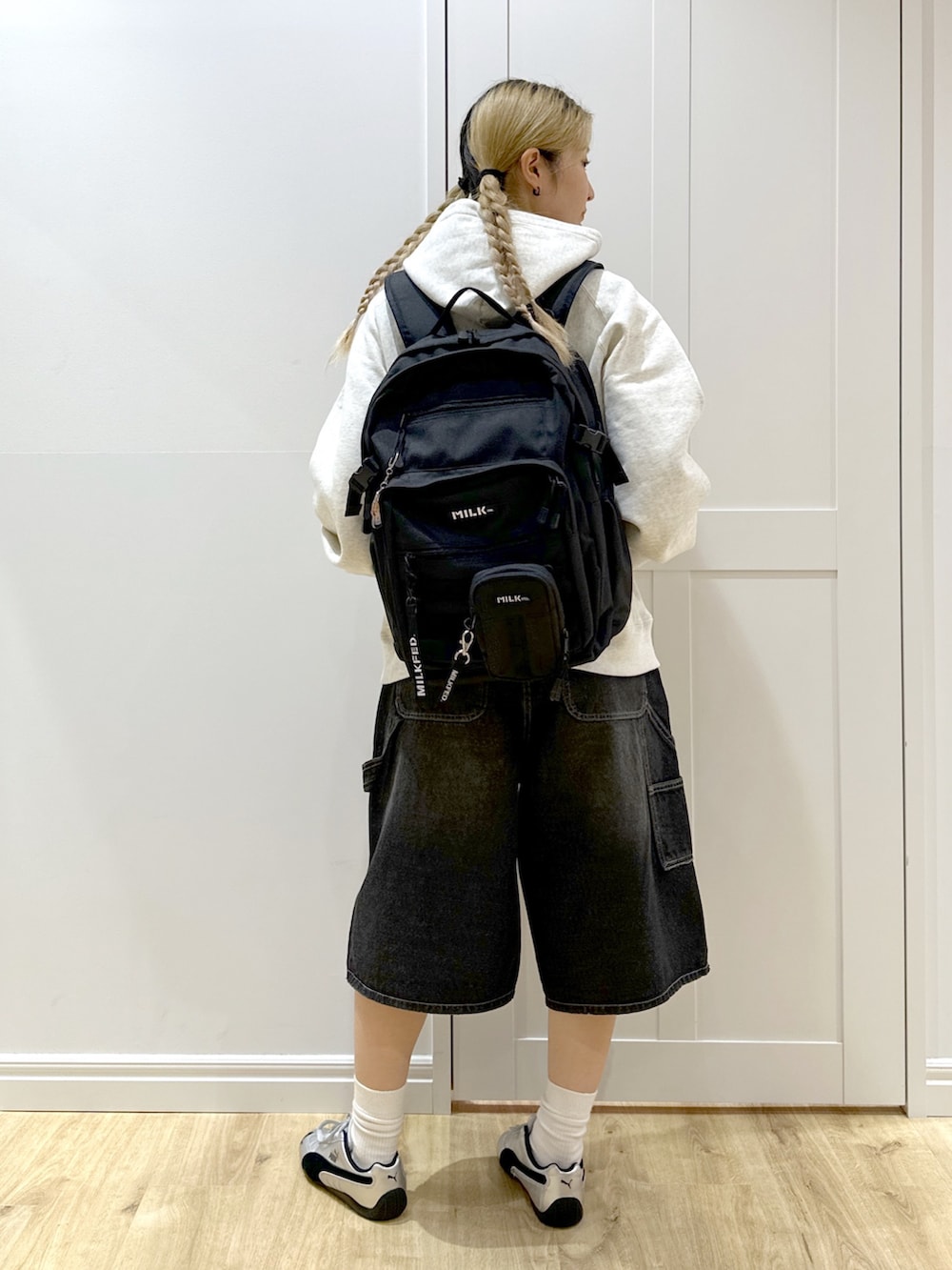 ベージュ系のパーカー、ブラック系のデニムパンツ、ブラック系のバックパック/リュックを着用したレディースの秋コーディネートの2枚目の写真